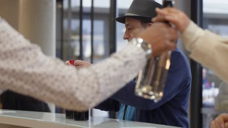 Senior-customer-buying-two-bottles-of-red-wine-in-the-supermarket