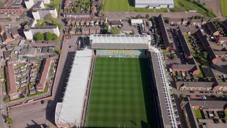 Vista-Aérea-Del-Estadio-De-Rugby-De-Los-Northampton-Town-Saints-Mirando-Hacia-Abajo-E-Inclinado-Hacia-Arriba-A-Través-Del-Horizonte-De-La-Ciudad