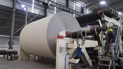 A-roll-of-paper-is-being-prepared-by-large-machines