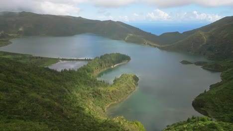 Üppige-Grüne-Berge-Umgeben-Den-Ruhigen-Lagoa-Do-Fogo-See-Unter-Einem-Teilweise-Bewölkten-Himmel