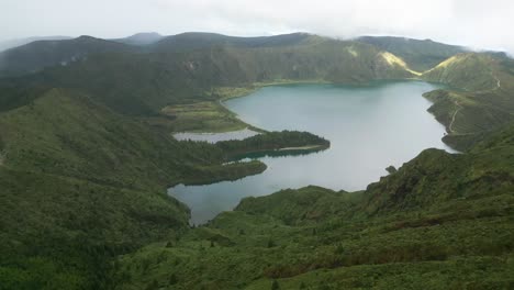 Lagoa-do-Fogo-lake-and-green-hills-at-cloudy-Azores,-forward-aerial