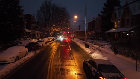 Langsamer-Drohnenschuss-über-Einer-Matschigen-Straße-Bei-Nächtlichem-Schneefall