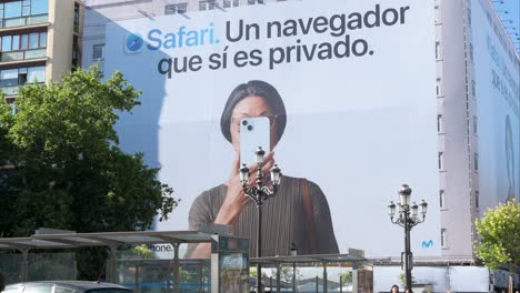 En-El-Centro-De-Madrid,-La-Gente-Pasa-Junto-A-Un-Destacado-Cartel-De-Apple,-La-Multinacional-Tecnológica-Estadounidense.