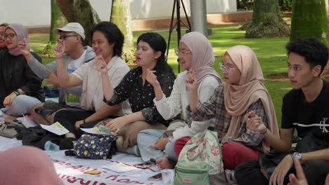 People-sit-in-park-in-Indonesia-and-learn-sign-language-for-hearing-impaired