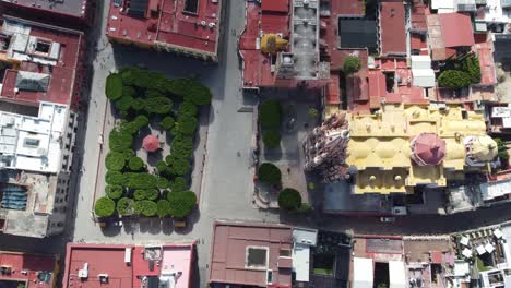 San-miguel-de-allende's-colorful-buildings-and-central-plaza-with-lush-greenery,-aerial-view