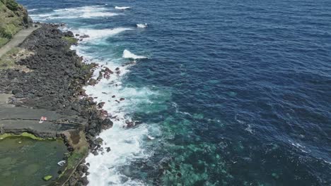 Volcanic-black-coast-with-road-and-blue-sea,-Sao-Miguel,-Azores-islands