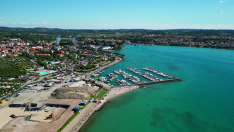 High-angle-aerial-over-shoreline-of-Peschiera-del-Garda-lake,-Verona,-Italy-4K-stock-video