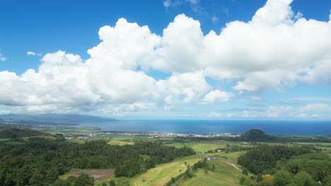 Scenic-aerial-view-of-Lagoa-do-Fogo-with-lush-greenery-and-blue-sky