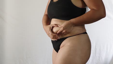 Overweight-adult-Hispanic-woman-in-underwear-examines-her-body
