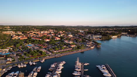 High-angle-aerial-over-shoreline-of-Peschiera-del-Garda-lake,-Verona,-Italy-4K-stock-video