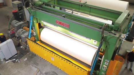 A-large-machine-is-visible-in-which-a-small-roll