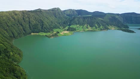 Sete-Cidades,-Ein-Grüner-See,-Umgeben-Von-üppigen-Hügeln-Und-Feldern-Auf-Den-Azoren,-Luftaufnahme