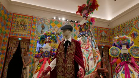 Dolce-And-Gabbana-Luxurious-and-ornate-Fashion-clothes-on-mannequins-showcased-in-exhibition-room,-exuding-a-sense-of-opulence-and-artistic-flair