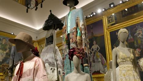 Dolce-And-Gabbana-Luxurious-Fashion-dresses-on-mannequin-displays-showcased-in-exhibition-room,-exuding-a-sense-of-opulence-and-artistic-flair