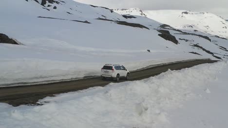 Driving-white-car-on-mountain-road-during-sunny-day