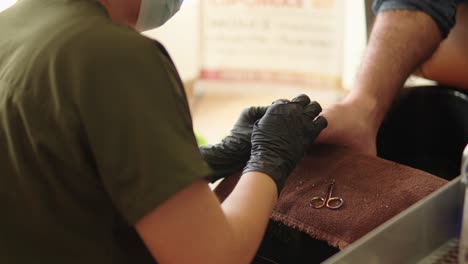 Pedicure-at-podiatry-center-spa-medical-wellness-resort-for-man-male-guy-latin-mexican-cutting-nails-with-scissor-and-clean-with-tweezers