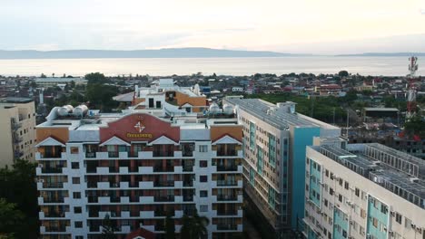 La-Vista-Aérea-De-Un-Dron-Captura-Dos-Condominios-Uno-Al-Lado-Del-Otro,-Elevándose-Sobre-Un-Fondo-De-Casas-De-Bajo-Costo,-Resaltando-El-Marcado-Contraste-En-Las-Condiciones-De-Vida-Urbanas.