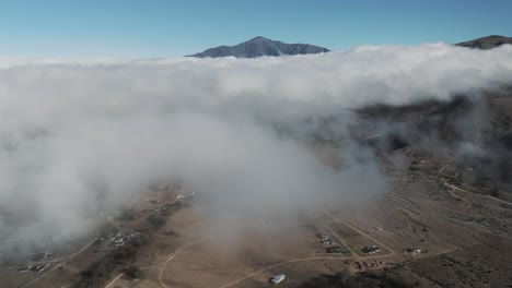 Vista-Aérea-De-Drones-Pasando-A-Través-De-Nubes-Sobre-La-Ciudad-De-Tafí-Del-Valle-En-Tucumán,-Argentina