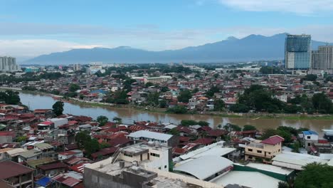 Drohnen-,-Luft--Und-Kinoaufnahmen-Von-Davao-City-Mit-Dem-Fluss-In-Der-Mitte-Und-Einem-Berg-Im-Hintergrund