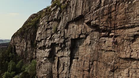 Mädchen-Klettert-Felsige-Klippe-In-Norwegen,-Extremsport,-Luftaufnahme