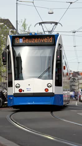 Dutch-Tram-on-Busy-Street,-Public-Transport-Netherlands,-Gbv-Blue,-White,-Tram-on-Electricity-Line-13-to-Geuzeveld