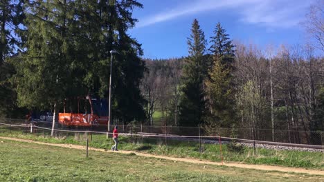 Funicular-cable-car-driving-down-in-Gubalovka,-Zakopane,-Poland-in-sunny-day,-panning-shot