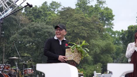 Famosa-Personalidad-Política-Indonesia-Sonriendo-En-Un-Escenario-Al-Aire-Libre-Sosteniendo-Una-Maceta