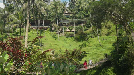 Mujeres-Con-Vestidos-Largos-Caminando-Sobre-El-Puente-Danzante-En-Alas-Wangru-Bali-En-Tegallalang,-Bali,-Indonesia