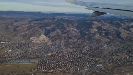 Flying-Above-Residential-Suburbs-of-Reno,-Nevada-USA,-Airplane-Passenger-POV-Over-Wing