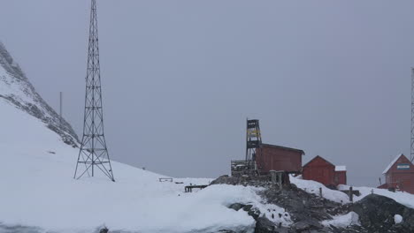 Research-Station-on-Coast-of-Antarctica,-Base-Buildings-and-Tower-on-Snowy-Day,-Slow-Motion