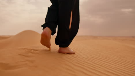 Close-up-of-bare-feet-walking-on-sand-dunes-in-the-Sahara-Desert