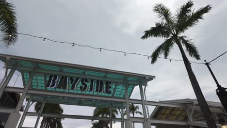 Outdoor-view-of-Miami's-Bayside-Market-with-palm-trees-and-cloudy-sky