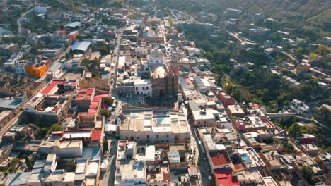 Una-Encantadora-Vista-Aérea-De-Un-Dron-Que-Captura-Un-Pintoresco-Pueblo-Mexicano-En-Medio-De-Un-Impresionante-Paisaje-Montañoso