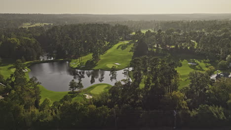 Augusta-Georgia-Aerial-v59-cinematic-drone-flyover-around-the-National-Golf-Course,-capturing-sunset-views-of-the-lush-fairways,-lake,-and-cityscape---Shot-with-Mavic-3-Pro-Cine---October-2023