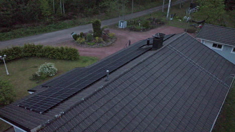 Vista-Aérea-Alrededor-De-Colectores-De-Luz-Solar-En-El-Techo-De-Una-Casa,-Tarde-De-Verano