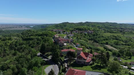 lush-green-summer-aerial-in-the-hillside-town-of-Gabiano,-Italy