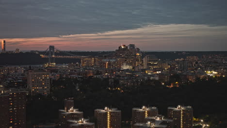 Paso-Elevado-Aéreo-V257-De-Nueva-York-Que-Captura-La-Zona-Residencial-De-Washington-Heights-En-El-Alto-Manhattan-Y-Fort-Lee-A-Través-Del-Río-Hudson-Contra-El-Cielo-Del-Atardecer---Filmado-Con-Inspire-3-8k---Septiembre-De-2023