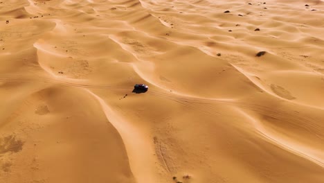 Aerial-view-of-a-pickup-truck-traveling-through-the-vast-Northern-Chinese-Tengger-Desert,-Inner-Mongolia-Autonomous-Region,-China