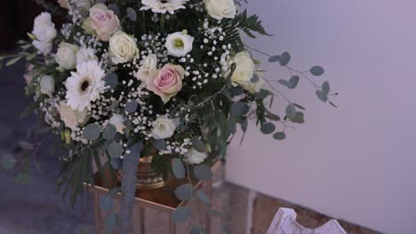 Elegantes-Blumenarrangement-Mit-Rosen-Und-Grünpflanzen-In-Einer-Kirchlichen-Umgebung