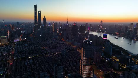 Toma-Aérea-De-La-Icónica-Zona-Financiera-De-Pudong-Lujiazui-De-Shanghai-Durante-Un-Vibrante-Panorama-Del-Atardecer