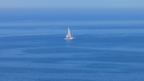 Velero-Flotando-En-El-Tranquilo-Océano-Azul-Cerca-De-España