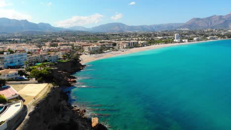 Aerial-footage-with-a-seagull-facing-the-camera-who-flies-very-close-to-the-drone-on-the-beach-of-Costa-Blanca,-Spain