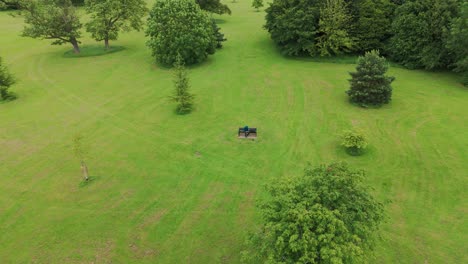 Aerial-shot-of-a-tourist-man-sitting-on-a-bench-in-Priory-Park-during-daytime-in-England