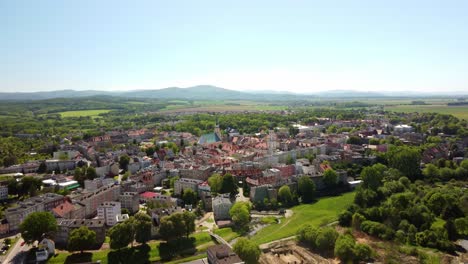 Historische-Stadtgebäude-Und-üppige-Landschaft,-Eingerahmt-Von-Fernen-Hügeln-Unter-Einem-Klaren-Blauen-Himmel