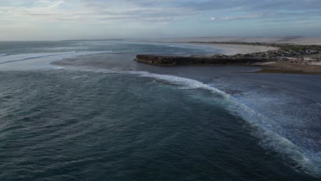 Aerial-establishing-shot-of-Cactus-Beach-with-waves-from-ocean-at-sunset-in-Australia