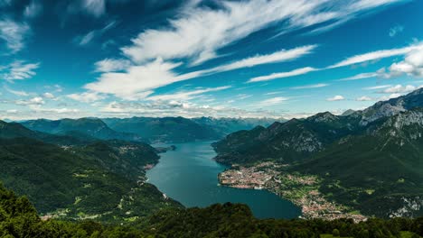 Stunning-panoramic-Timelapse-view-of-a-lake-surrounded-by-lush-green-mountains-under-a-clear-blue-sky-with-clouds