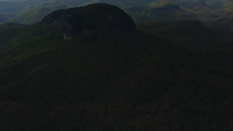 Aerial-revealing-Looking-Glass-Rock-towering-over-Asheville-NC-mountains