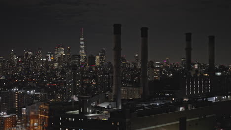 NYC-New-York-Aerial-v306-flyover-and-around-power-generating-station-capturing-cityscape-of-Lower-Manhattan-and-Brooklyn-Downtown-across-East-river-at-night---Shot-with-Inspire-3-8k---September-2023