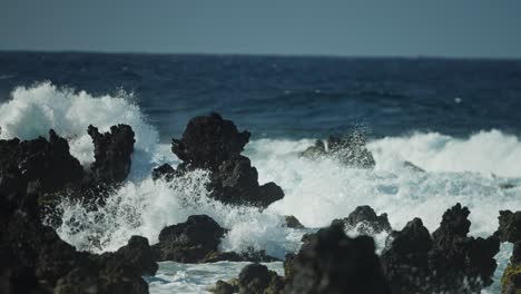 Rocas-Irregulares-De-Lava-De-Basalto-Sobresalen-Del-Océano-Mientras-Las-Olas-Chocan-Rociando-Niebla-De-Cal-En-El-Aire