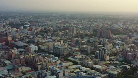 Drones-Aéreos-Sobrevuelan-El-Vecindario-Capturando-El-Paisaje-Urbano-De-Edificios-Residenciales-Y-Comerciales-De-La-Ciudad-De-Douliu,-Condado-De-Yunlin,-Taiwán-Al-Atardecer